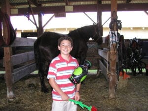 boy holding rose in front of horse at the Ontario County Fair in Canandaigua