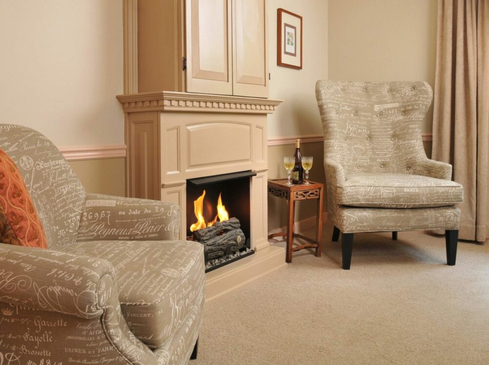 Angell Room with blazing fireplace and 2 chairs