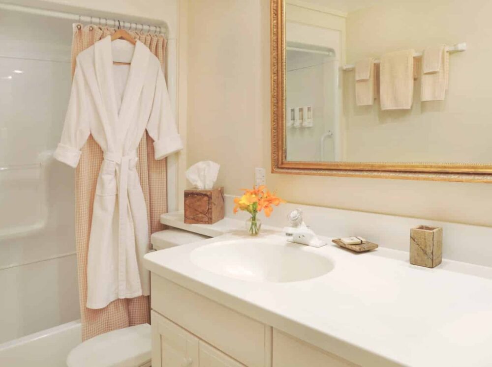 bathroom with white robe hanging on shower