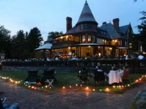 Moonlight Stroll at Sonnenberg Gardens and Mansion, located in Canandaigua, with people sitting in chairs outside the lit-up mansion listening to music... just ten minutes from the 1795 Acorn Inn B & B.