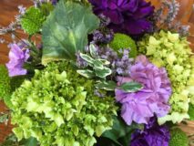 A beautiful flower arrangement of green hydrangea and purple carnations