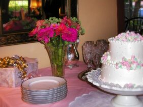 decorated wedding cake and pink flowers with gifts ready for the serving